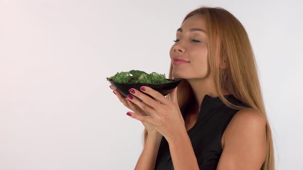 Happy Healthy Woman Enjoying the Smell of Fresh Delicious Salad