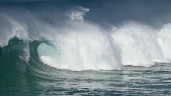 Great Turquoise Colored Wave Rolling and Hitting the Sea Coast Broducing Many White Splashes Just