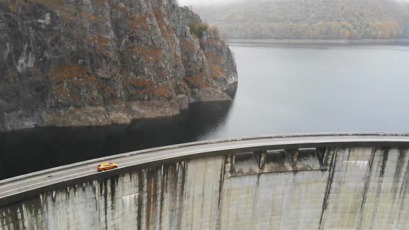 Aerial Shot of Car Riding at Dam in Autumn Mountain Road