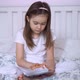 Girl Browsing Tablet on Bed - VideoHive Item for Sale