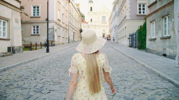 Smiling Woman Walking on Town Street. Smiling Young Lady Looking Back at Camera While Walking