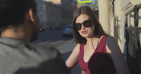 A Loving Heterosexual Attractive Couple is Talking at a Table in a Street Cafe