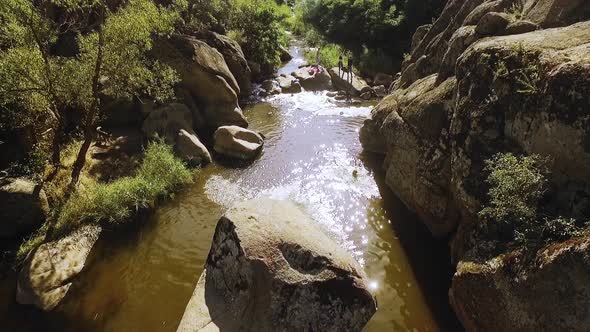 Caucasian Male Jumping Into River From Huge Boulder in Slowmotion