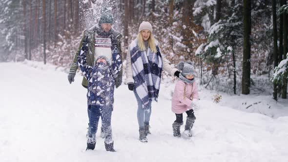 Video of family with two children walking in winter forest. Shot with RED helium camera in 8K.