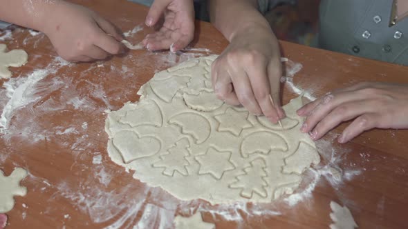 A little girl with her mother are preparing gingerbread