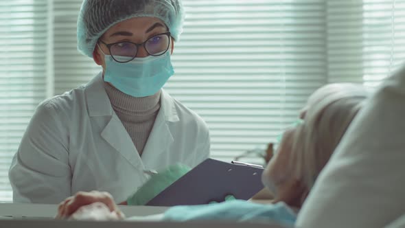 Doctor in Mask Giving Consultation to Elderly Female Patient