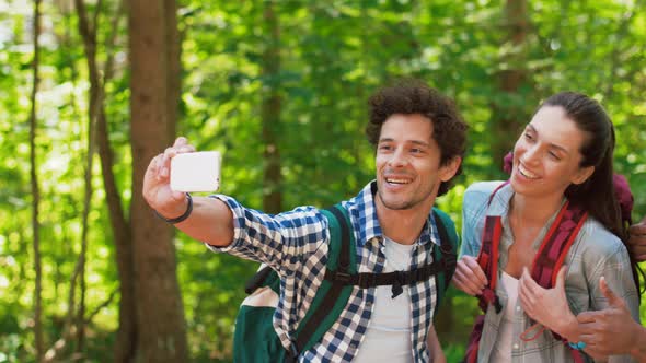 Friends with Backpacks Hiking and Taking Selfie