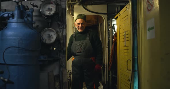Positive Aged Mechanic Working on Fishing Ship