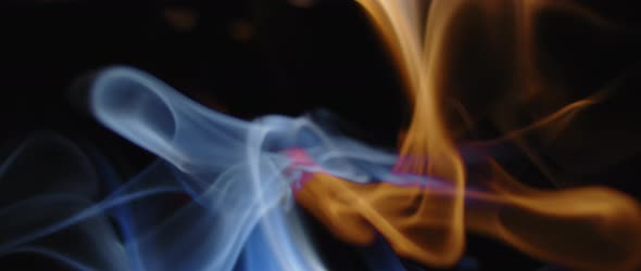 Blue and yellow incense swirling on black background