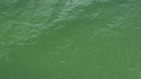 Rotating Shot of Waves Crashing on the Surface of Green Sea 