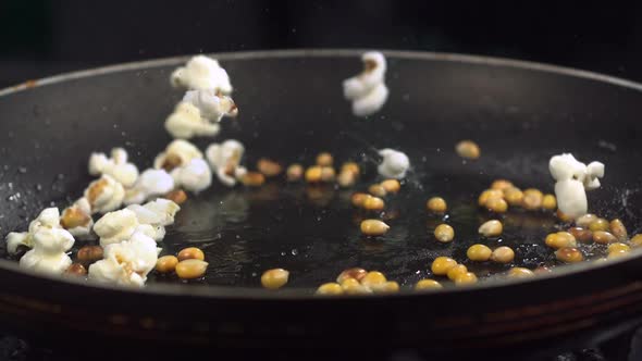 Popcorn popping on black background, Slow Motion