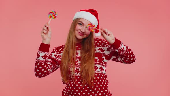 Funny Girl in New Year Sweater Holding Candy Striped Lollipops Hiding Behind Them Fooling Around