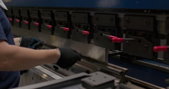 Factory Worker Bends Metal Parts on a CNC a Factory Machine