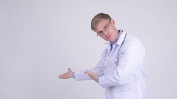 Happy Young Handsome Man Doctor Showing Something