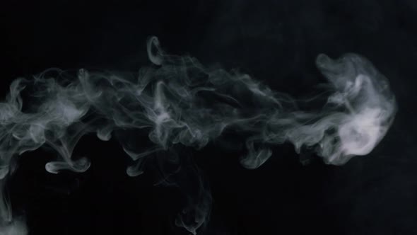 Closeup of Smoke Rings Smoking Hookah or Cigarette in Dark Studio View Side of Blowing Out Puffs of