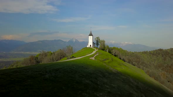 drone footage sunset at Church of St. Primus and Felician, Jamnik, Slovenia