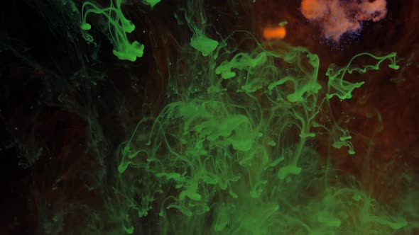 Mixing Particles of Glowing Colors of Green and Red Paint in Smoke