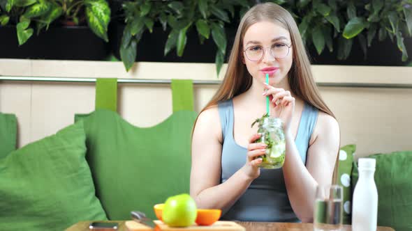 Portrait of Smiling Beautiful Fitness Girl Drinking Healthy Beverage Posing at Modern Kitchen