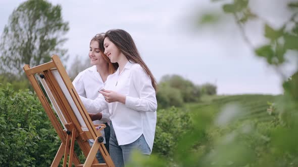 Elegant and Beautiful Girls Painting in a Field