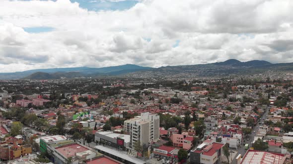 Aerial panoramic view of southern Mexico City. Drone flying backwards and slowly descending with vie