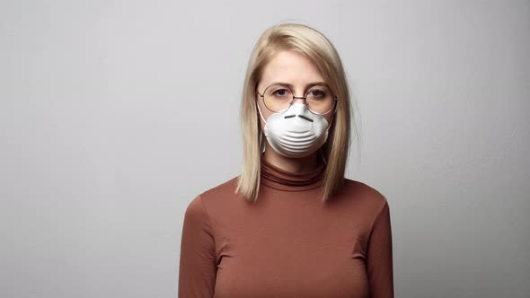 Blonde woman in protective mask on grey background