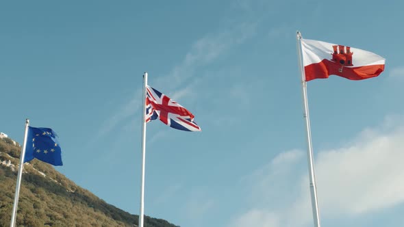 Flags of the European Union United Kingdom and Gibraltar Day Clouds Sun