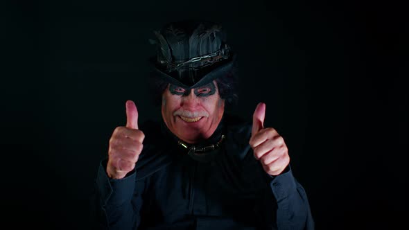 Sinister Elderly Man with Scary Halloween Witcher Makeup in Costume Raises Thumbs Up Like Gesture