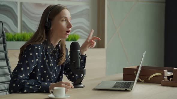 Woman with Microphone and Laptop Computer Talking and Recording Podcast at Studio