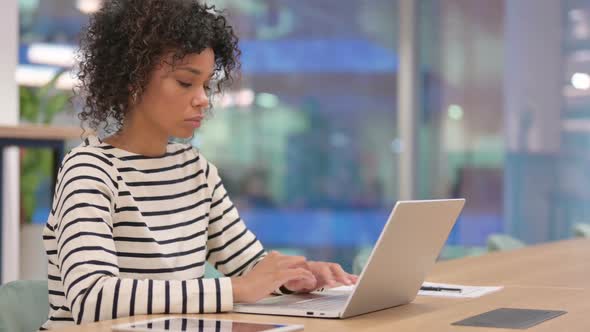 African Woman Working on Laptop in Office