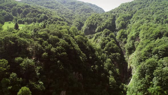 Aerial view of a person flying over the forest in zip-line at Slovenia