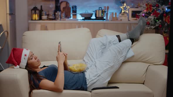 Woman Browsing Internet on Smartphone and Watching Television