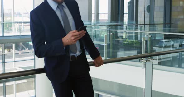 Businessman using smartphone in modern office building