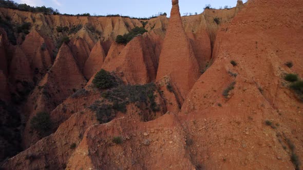 Epic drone flight small sandstone peaks inside crater named Las Carcavas against blue sky in Spain