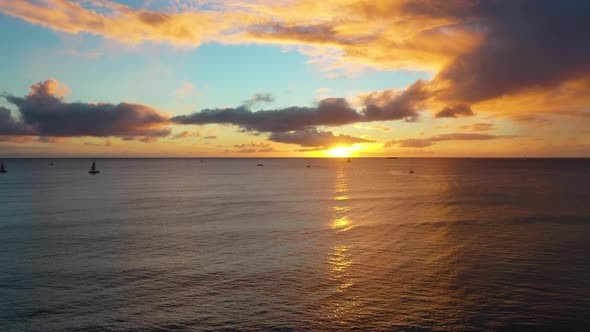 Drone Reveal of Beautiful Hawaiin Ocean Sunrise with Boats Sailing Over Waikiki Beach In Honolulu, H