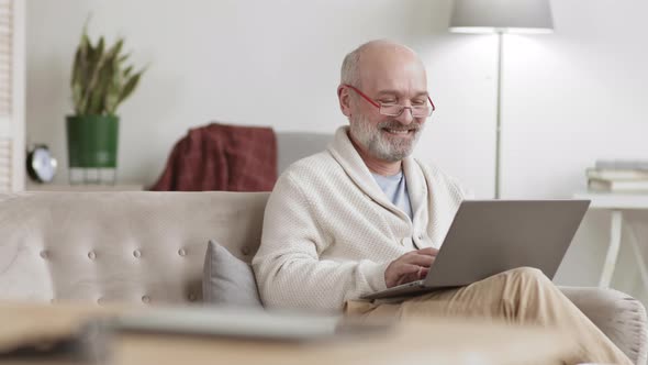 Portrait of Aged Man Using Laptop