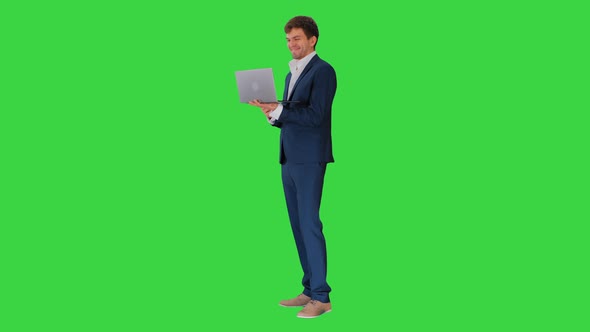 Smiling Young Businessman Using Laptop While Standing Green Screen Chroma Key