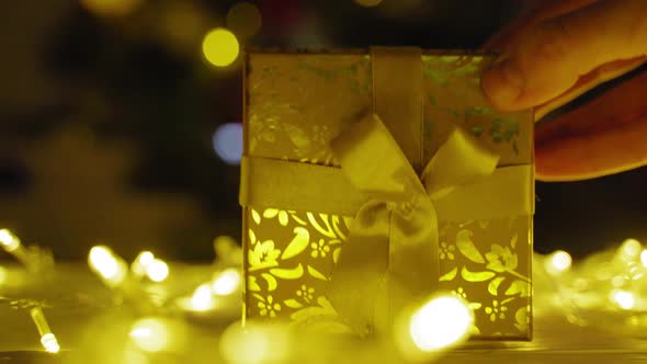 Christmas Present on Table Against the Background of the Christmas Tree