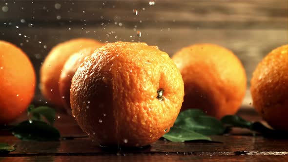 Drops of Water with Splashes Fall on Fresh Oranges