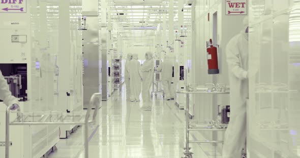 Workers in clean suits in a Semiconductor manufacturing facility