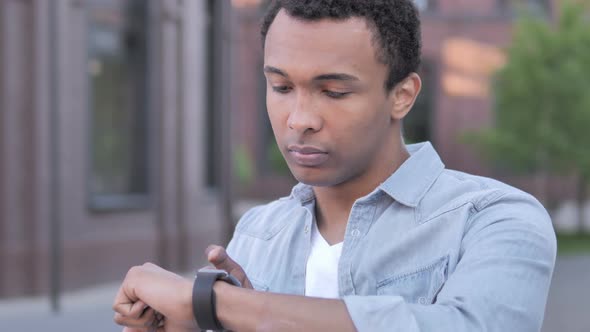 Young African Man Using Smartwatch