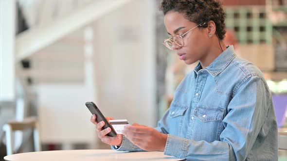 Successful Online Payment By African Woman on Smartphone at Cafe