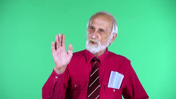 Portrait of Happy Old Aged Man 70s Communicates with Someone, Isolated Over Green Background.