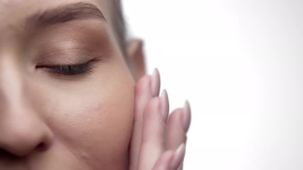 Closeup of Womans Eyes Rubbing Skin with Fingers After Spa and Cosmetic Procedures