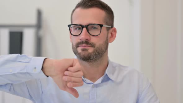 Portrait of Middle Aged Man Showing Thumbs Down Sign