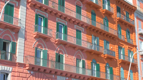 Low angle shot of old historic red colored building in Chiaia district in Naples, Italy on a bright