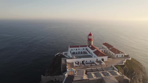 Aerial approaching Cabo de Sao Vicente lighthouse and convent, Sagres, Algarve