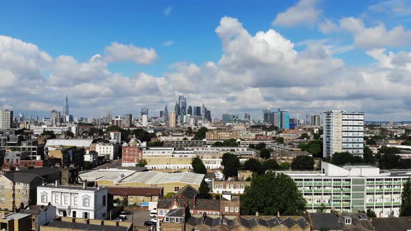 Aerial view raising above the flats in Shadwell revealing the London skyline