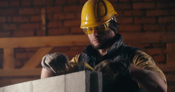Male Builder Measuring Brick Wall