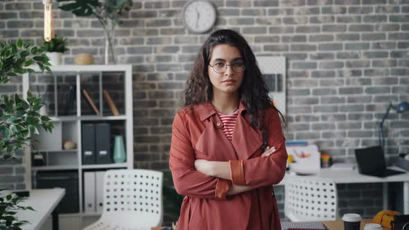 Portrait of Pretty Female Entrepreneur Standing in Office with Crossed Arms