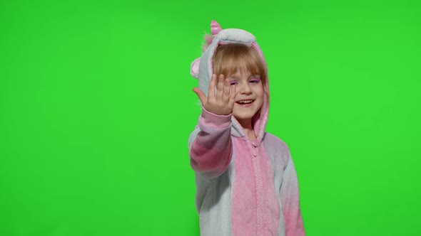 Little Child Girl Smiling Pointing at Camera Making Gun Gesture with Hands in Unicorn Pajamas